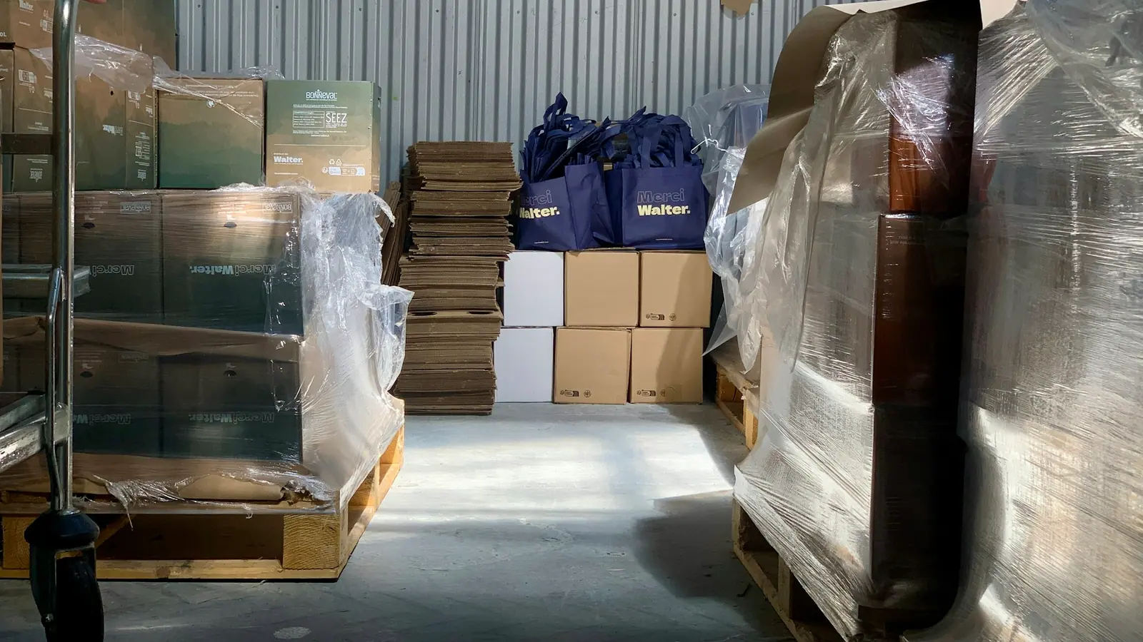 Stretch-wrapped pallets and cardboard cartons waiting in a warehouse dispatch area.