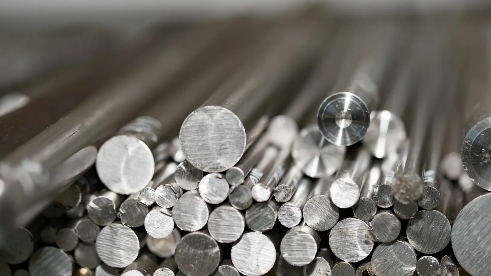 The cut ends of a bundle of aluminium and steel round bars of different diameters.